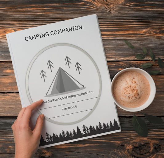 A wooden background with the Camping Companion a hand and a cup of coffee